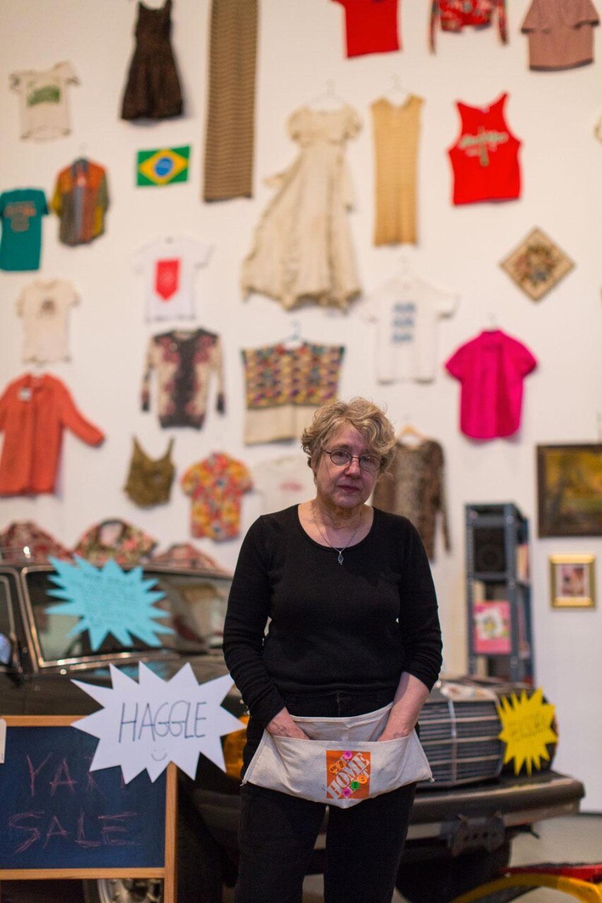 American artist Martha Rosler, standing amidst her <em>Meta-Monumental Garage Sale</em> installation at the Museum of Modern Art, New York. Photo by Scott Rudd