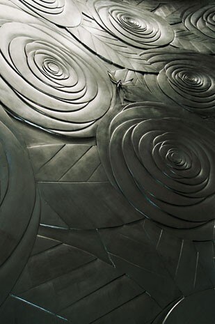 Details of the arabesque that runs along 
the walls of the main showroom and the stylised roses, gilded with white gold leaf, used to cover 
a wall linking two floors of the Salon