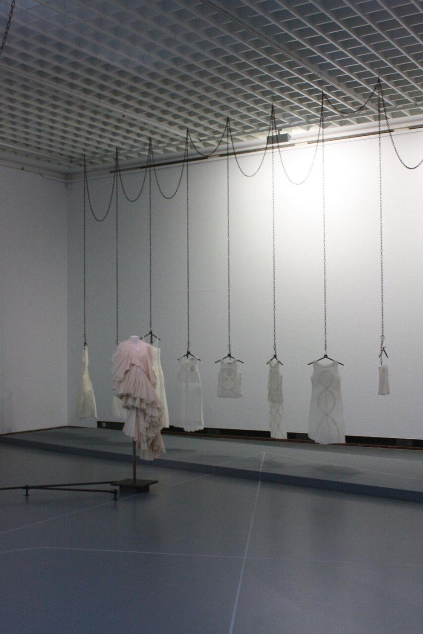 Installation view. In the foreground Comme des Garcons, 1997; in the background, Dirk Van Saerne s/s 1998 Crepe paper dresses