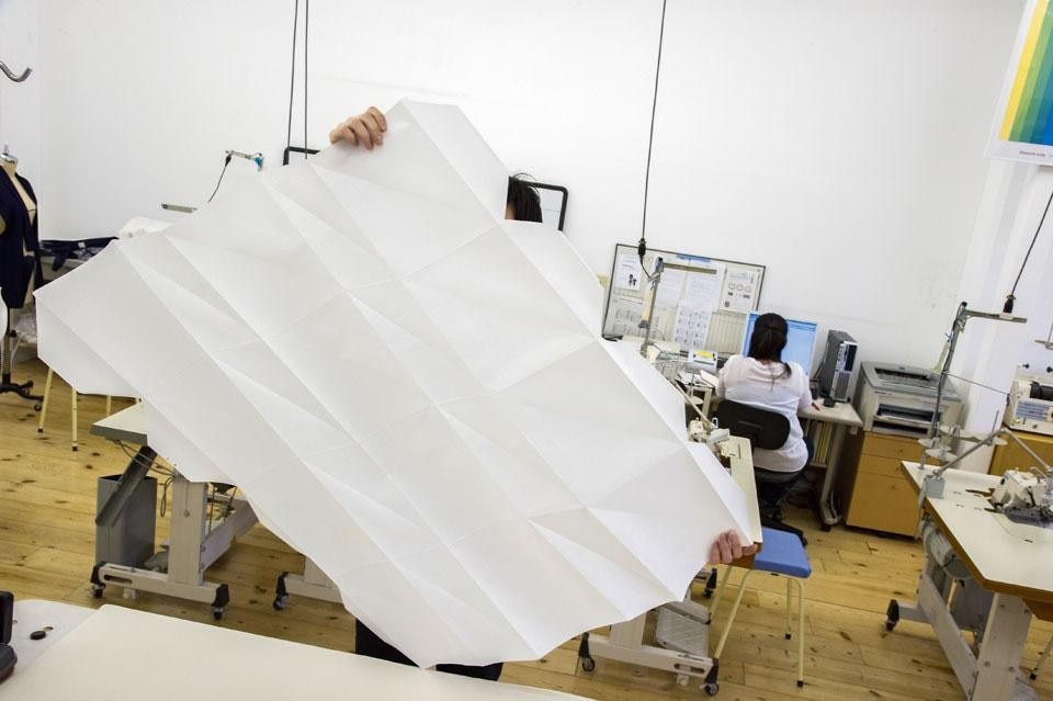 Folds are
made by hand on the sheet
of fabric, and ironed