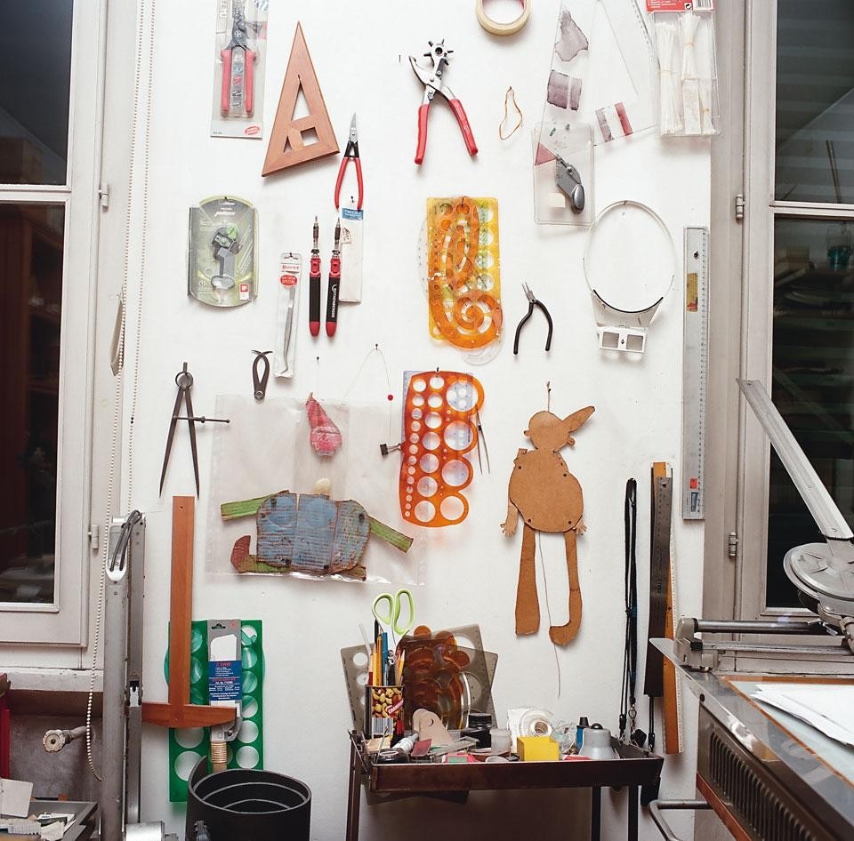 A collection of
work tools hanging on the
wall between two work
tables