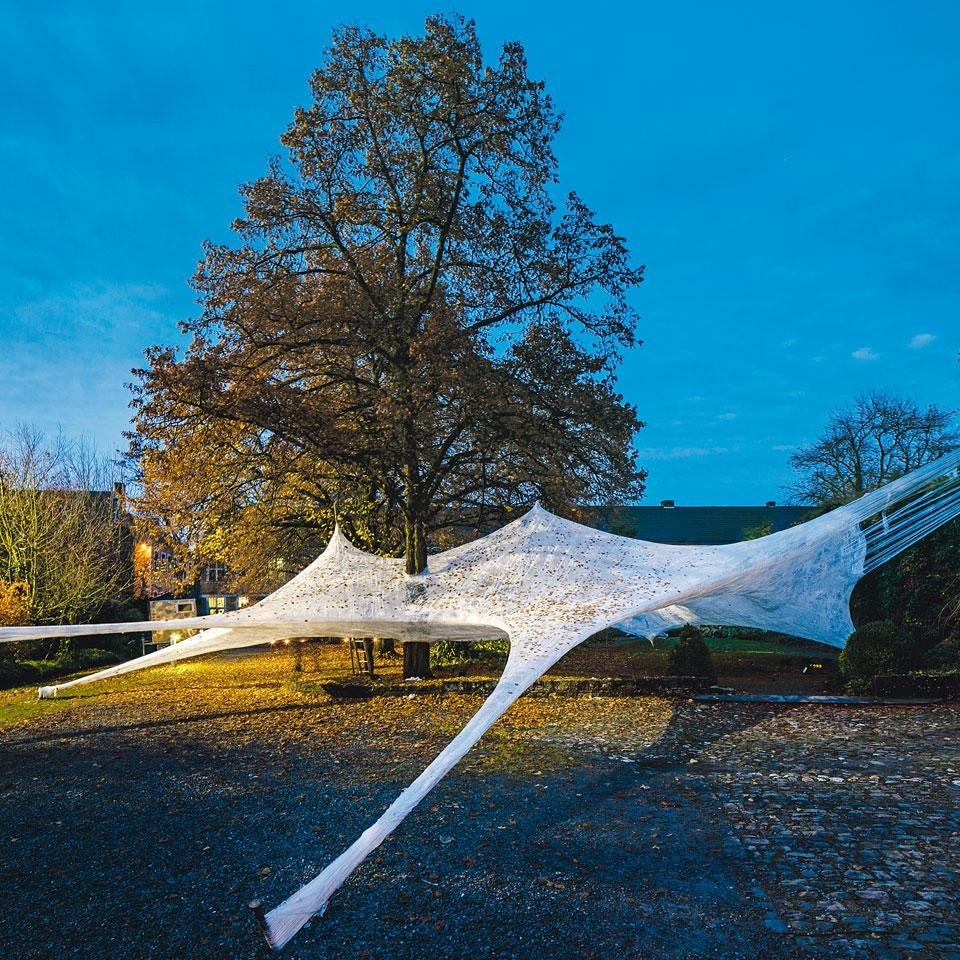 The <em>Tape Hasselt</em>
architecture-sculpture at the
Z33 House for Contemporary
Art. Suspended between
the trees, the work
was constructed with
superimposed layers of
transparent adhesive tape
wound round a light support
frame. It was created in
Hasselt last year by Z33
with Numen / For Use to
celebrate the art venue’s
tenth anniversary. Founded
by Jan Boelen in 2002, Z33
is a workshop/meeting place
that promotes a continuous
programme of temporary
exhibitions and art and design
projects in public spaces. Photo by Kristof Vrancken / Z33