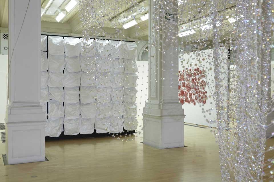 Opening photo: Tamar Frank (Netherlands) will create an enclosed space within the exhibition. A regular
lighting of the initially dark space will result in the installed grid of
phosphorescent threads glowing for a few minutes afterwards to
reveal a number of 3D parabolic shapes. Above: Atelier Manferdini (USA / Italy)
will create an inverted crystal cathedral using one
tonne of crystal, including over 600 strands of Swarovski elements. Multiple
strings of crystals will descend from a
7x7 metre space on the ceiling to create a structure that will hang down to
the floor, referencing the Italian expression ‘punto in aria’—stitching the air.