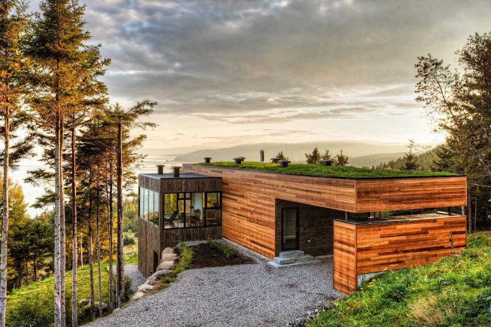 A wide gateway acting as a carport and covered entrance rests on a retaining wall/storage unit that was necessary given the condition of the very steep terrain A wide gateway acting as a carport and covered entrance rests on a retaining wall/storage unit that was necessary given the condition of the very steep terrain