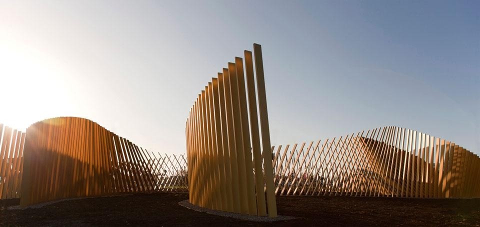 A series of anodised aluminium staves are set in the ground in long arrays
which give the impression of giant forms in the landscape