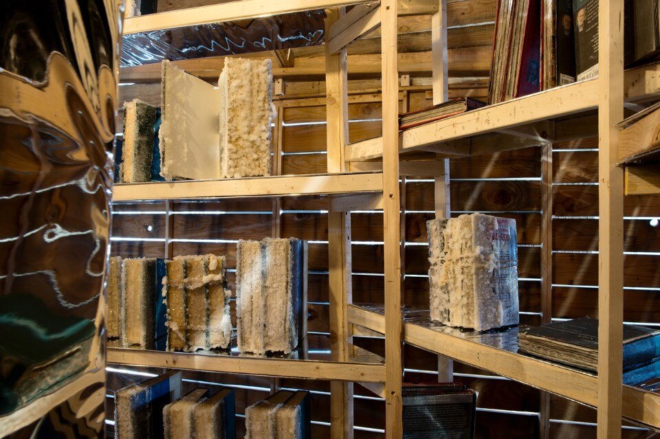 Edgar Arceneaux  Library of Black Lies, 2016  Wood, mirror, glass, mylar, newspaper, hardbound books, sugar crystals, lighting fixture, audio component.  Courtesy of the artist, Susanne Vielmetter Los Angeles Projects, and Galerie Nathalie Obadia, Paris/Bruxelles.. Photo © Hélène Hilaire, 2016.