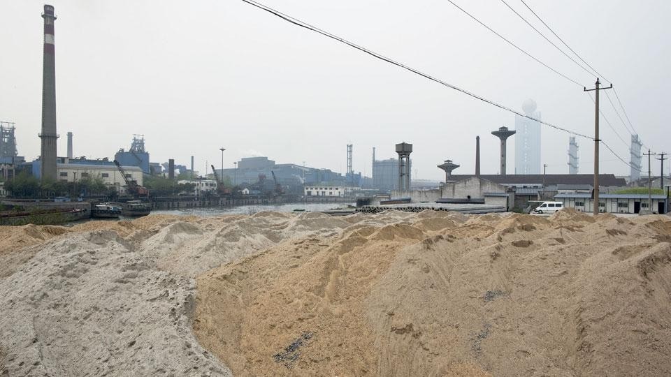<b>Top</b>: River Factory of the Village. Huaxi cement factory. Among China’s industrial
villages, Huaxi is one of the few with technologyintensive
heavy industries that provide the
foundation for the village’s growth, in contrast to
villages with labour-intensive light industries. <b>Above</b>: Village Factories and Docks. The ore dock at Huaxi cement factory by the
Zhangjiagang River, with Huaxi Steel Factory on the
opposite side