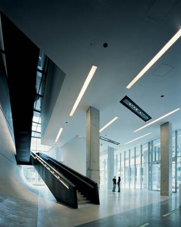 Disegnato come se fosse un proseguimento della strada, il piano terra è uno spazio pubblico che dà il benvenuto ai visitatori. Impilata su di esso, una serie di volumi solidi sembra fluttuare nell’aria