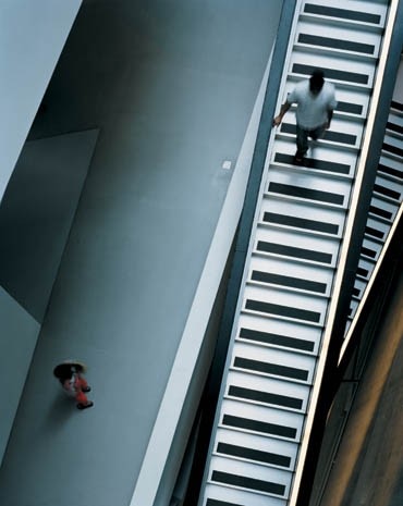 Il baratro della scala – di cemento armato, con poderosi gradini di acciaio prodotti da costruttori di ottovolanti – è un pezzo di arredo urbano, come le attrezzature delle strade e dei trasporti pubblici