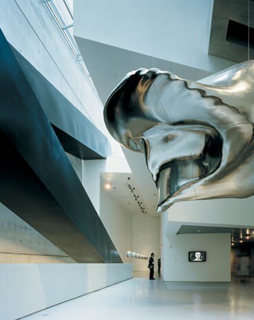 La contemplazione dell’arte taglia fuori le prospettive sulla città: che però poi ritornano, mentre il borbottio e lo strepito dei video fanno da surrogato al rumore del traffico