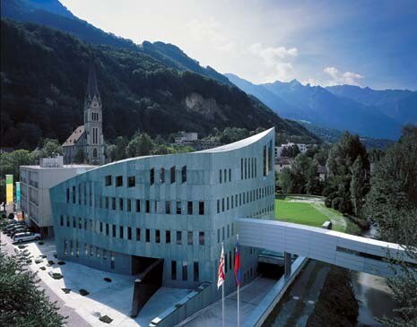 Il volume massiccio della banca sembra un gigantesco masso, rotolato dalla montagna sovrastante