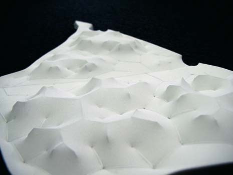 I progettisti hanno ideato un plastico in tessuto che materializza chiaramente il concetto di parco e le orografie di crinale e fondovalle. Le linee di crinale sono estruse grazie a un profilo metallico nascosto sotto il tessuto, mentre le linee di fondovalle sono ricamate con un filo