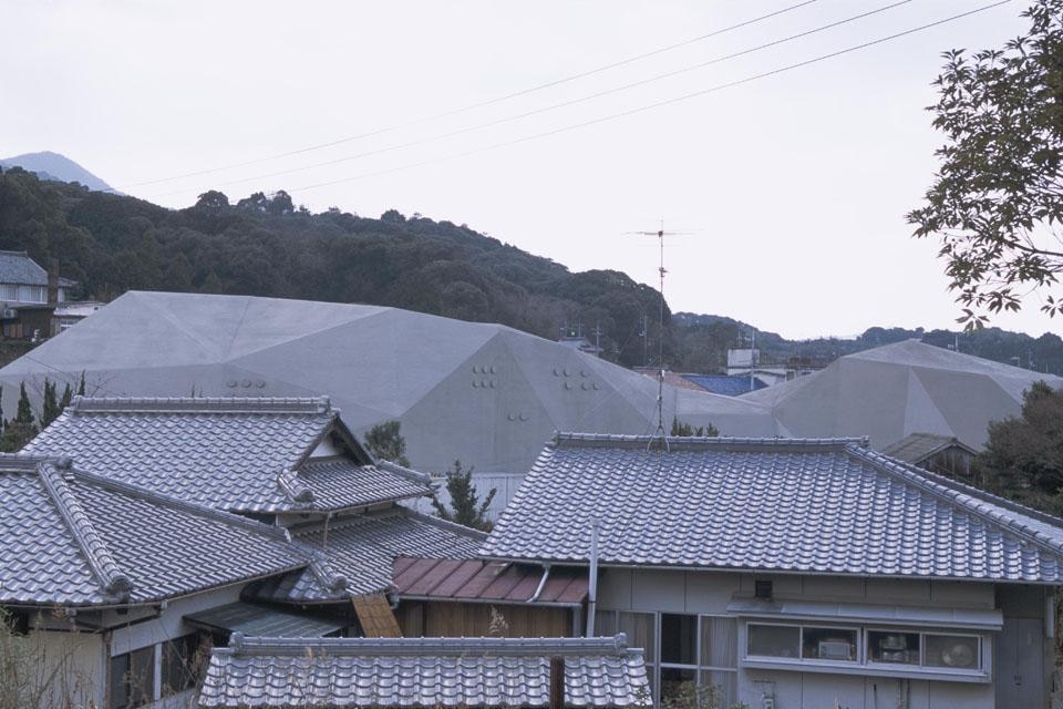 Gli edifici seguono organicamente l'andamento del terreno sul quale poggiano e mimano il profilo delle montagne che si stagliano sul paesaggio che abbraccia la città. 