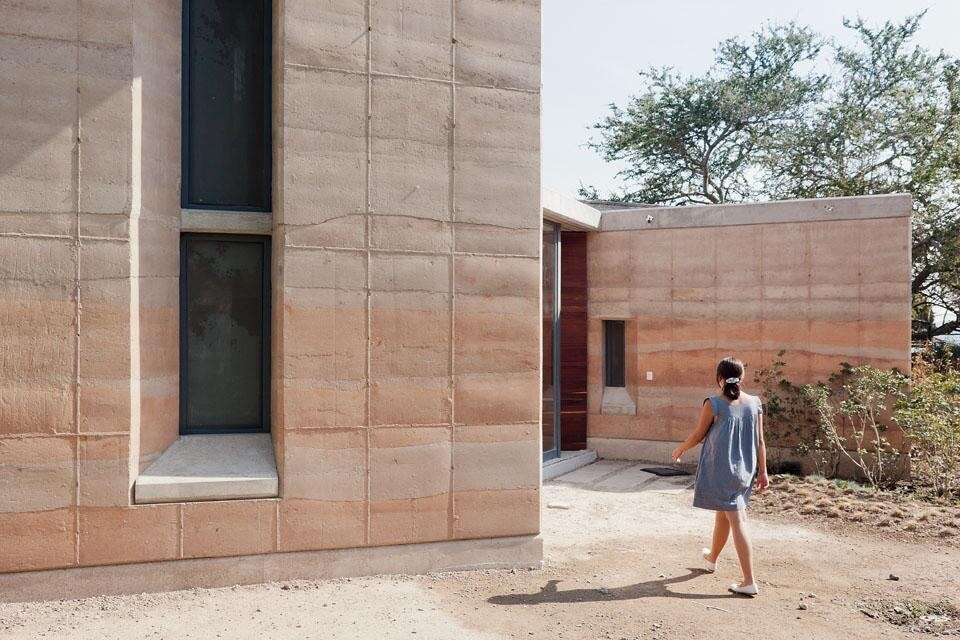Scorcio dell’ingresso. L’utilizzo della terra pressata consente all’architetto di confrontarsi con concetti contrastanti, quali trasparenza e compattezza. 
