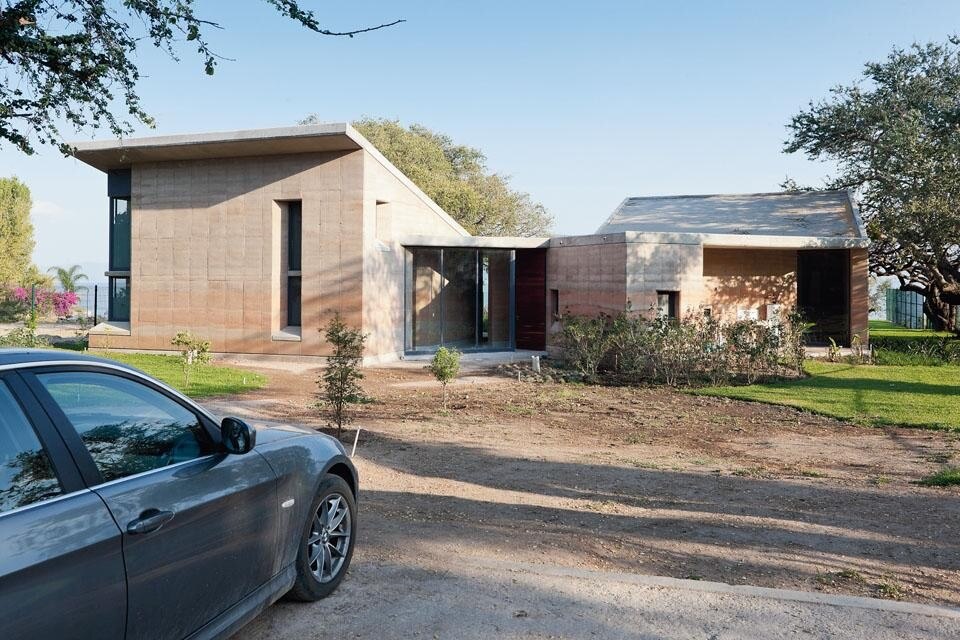 Veduta della facciata con l’ingresso principale. Bilbao è ricorsa alla terra pressata in modo da realizzare con un unico materiale sia la parte strutturale sia l’isolamento.