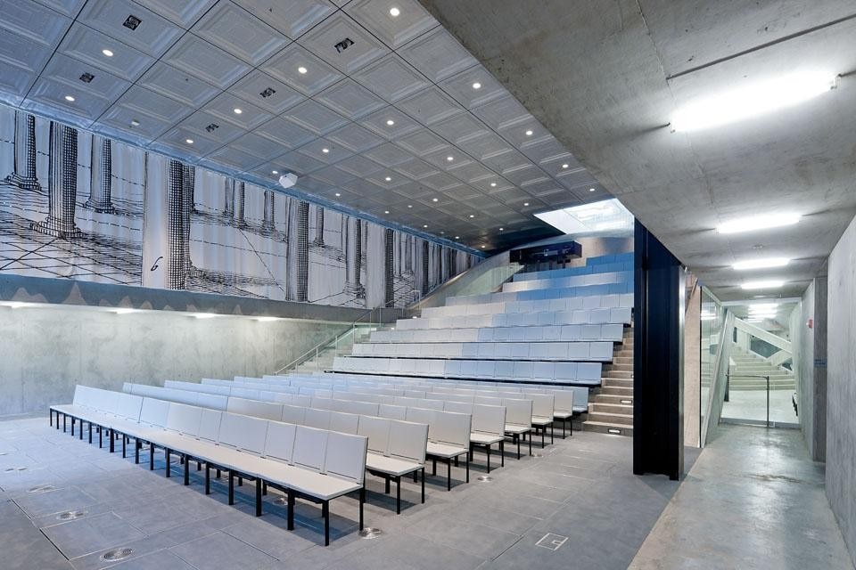L’auditorium
nel livello interrato. Le
tende disegnate da Petra
Blaisse rendono omaggio
all’architettura classica
 