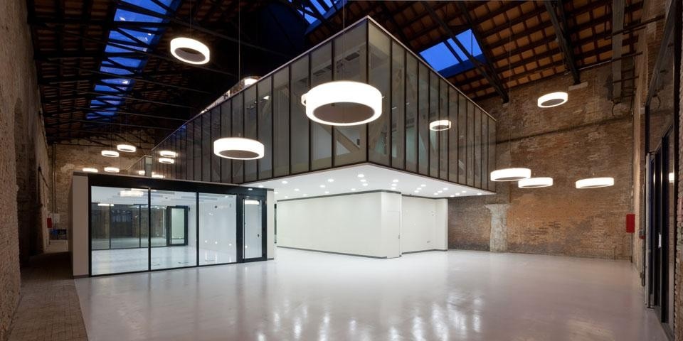 La distribuzione irregolare di 40 lampade circolari garantisce la luce artificiale e esalta l'articolazione dei volumi nello spazio del padiglione