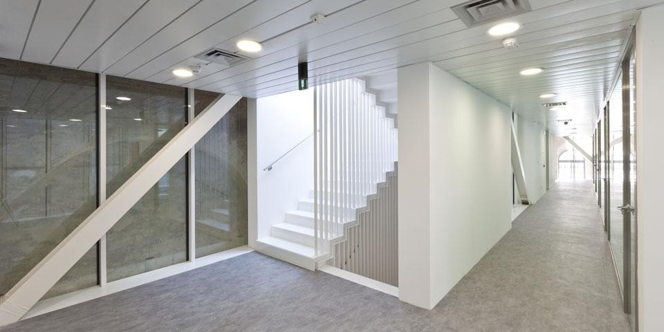 Un'abile sequenza in altezza di muri opachi bianchi e vetri trasparenti bianchi riempie lo spazio