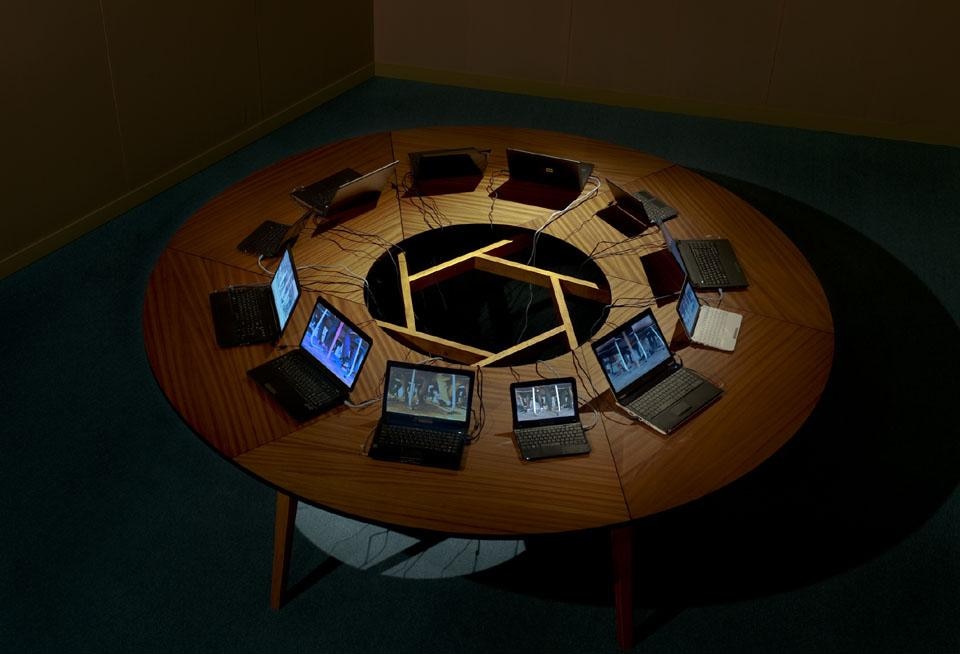 Sigalit Landau
Salt Bridge Summit, 2011
12 canali video e   installazione sonora, ?300 cm tavolo tondo in legno, 12 laptop, con il video “Laces”.
veduta dell'installazione© Sigalit Landau
Courtesy l'artista e kamel mennour, Parigi. Padiglione israeliano