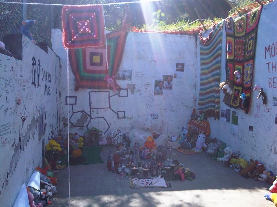 L'autore del monumento ha pubblicato un post in cui chiedeva, a chi volesse, di aiutarlo a costruire questo "altare di palese sentimentalismo", aggiungendovi "pupazzi di stoffa imbottita, scialli, pannocchie di granoturco essiccato e candele"