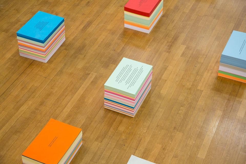 Alberto Garutti, <i>Didascalie</i>, 2012, stampa digitale su fogli di carta colorati, pile di fogli 43,5x64 cm, altezze variabili. Courtesy Massimo Minini 