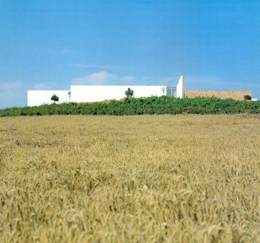 Casa a Alcanena, Portogallo, vista sud. La casa sorge su una collina in un'area completamente verde. Sulla sinistra la zona più 'domestica' della casa, intonacata, sulla destra la zona più 'pubblica', il lato di accesso, in pietra.