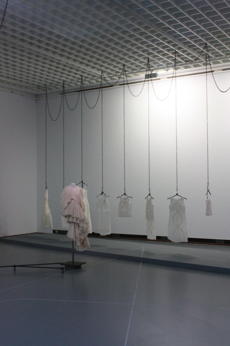 Allestimento della mostra. In primo piano Comme des Garcons, 1997; sullo sfondo, Dirk Van Saerne s/s 1998 Crepe paper dresses