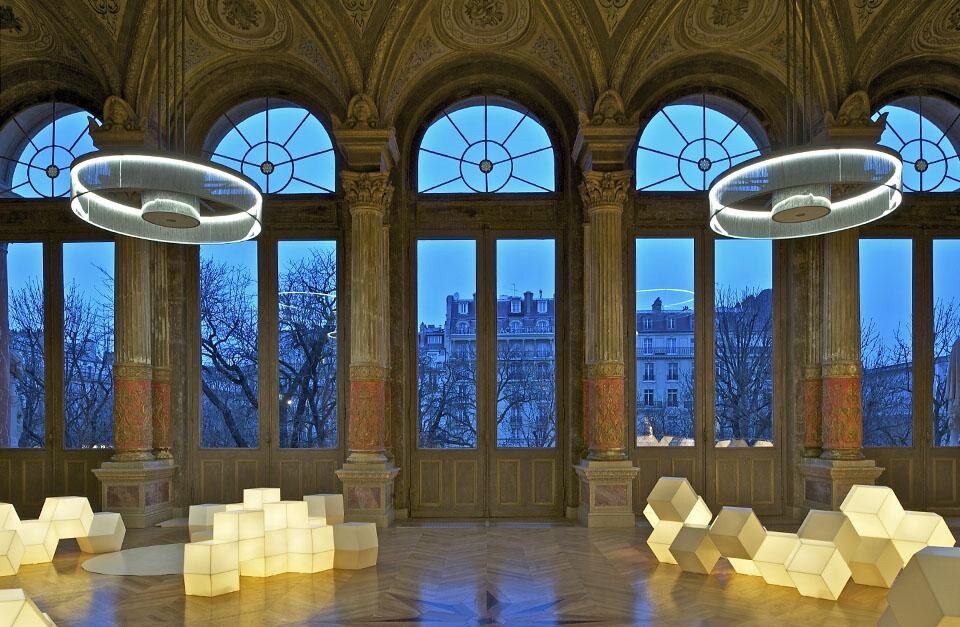 Protetto come monumento storico, il foyer dell'ex teatro ospita un caffé ed è illuminato da quattro grandi lampadari che riflettono il suono e la luce.  Photo © Philippe Ruault.