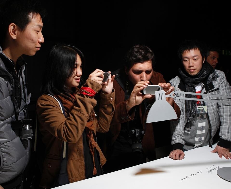 Studenti di Domus Academy intenti a fotografare i prodotti esposti in Fiera, a Euroluce