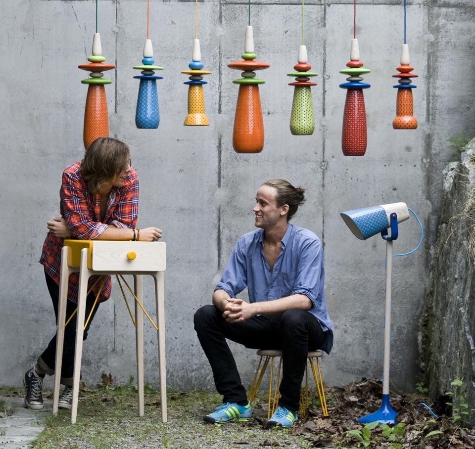 Mattias e Tor fotografati con la collezione di prototipi prodotti in Sudafrica: Forbidden Fruit — oggetti di ceramica decorata a mano (appesi) —, la lampada Last Fruit, la cassettiera e lo sgabello.
