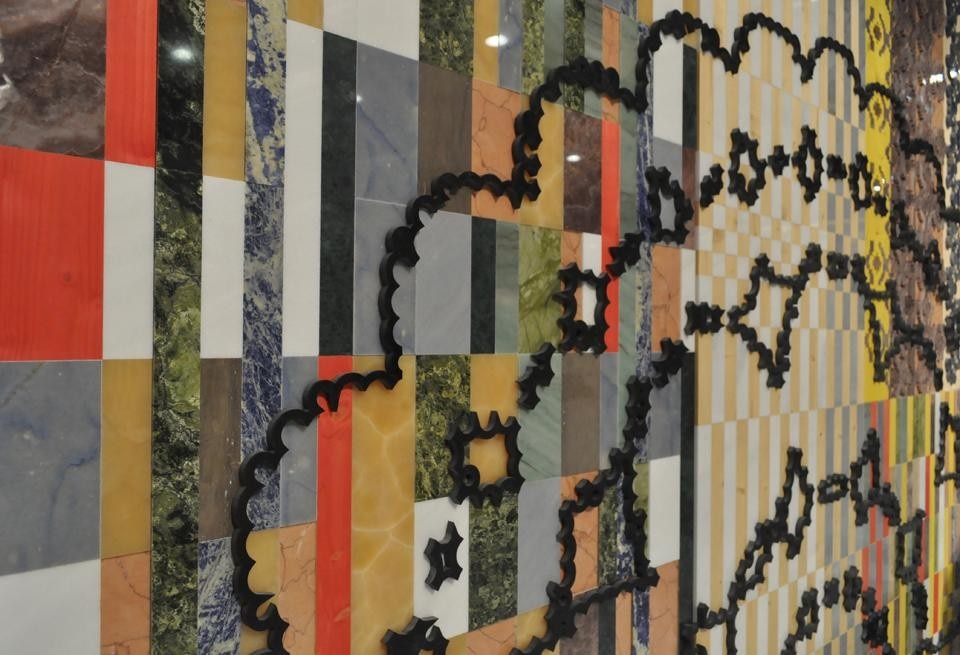 Il marmo bianco è accostato a inserti di legno color fluo e vetro satinato bianco.