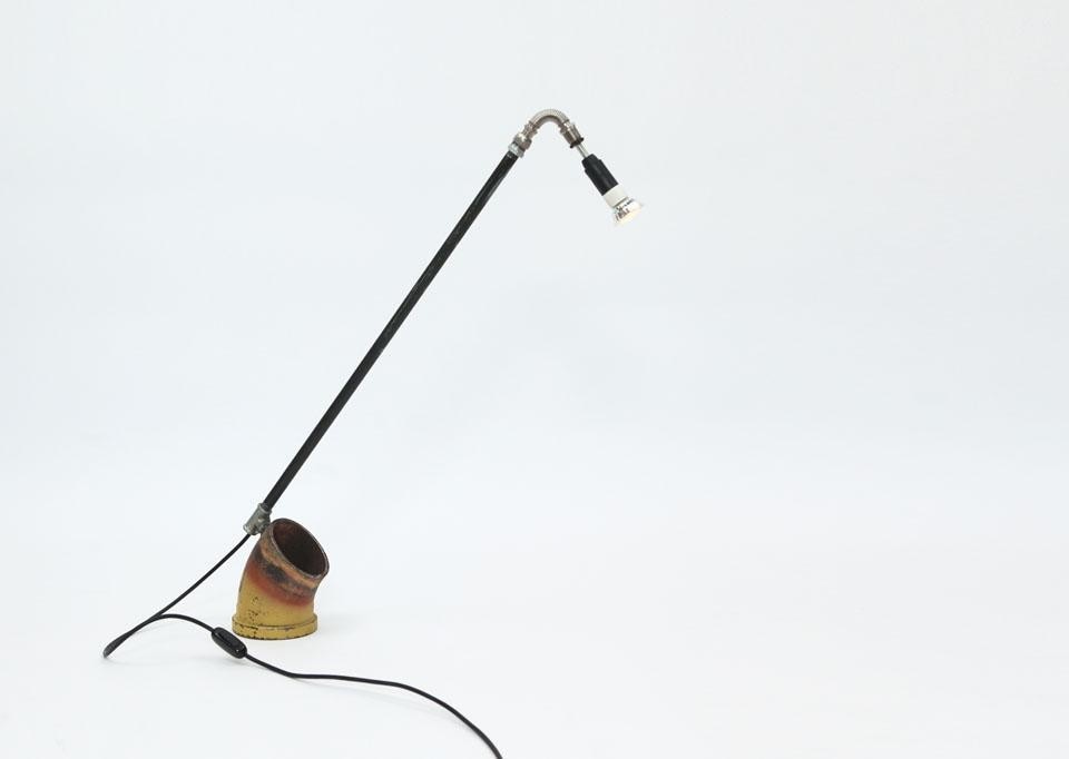 La lampada curva, la cui base è ricavata da una parte di tubo
