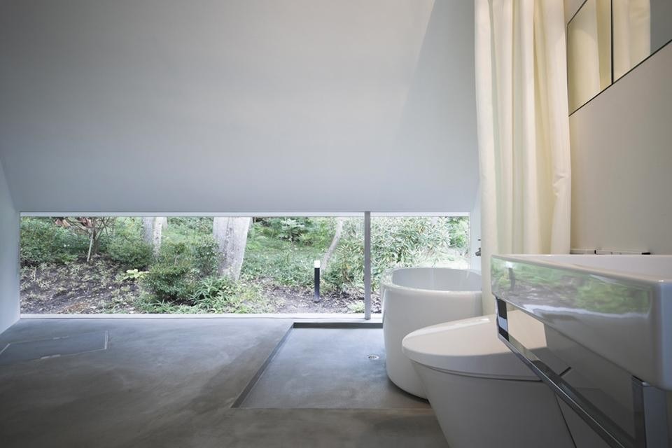 La finestra del bagno a tutta parete a livello del terreno, per garantire la privacy