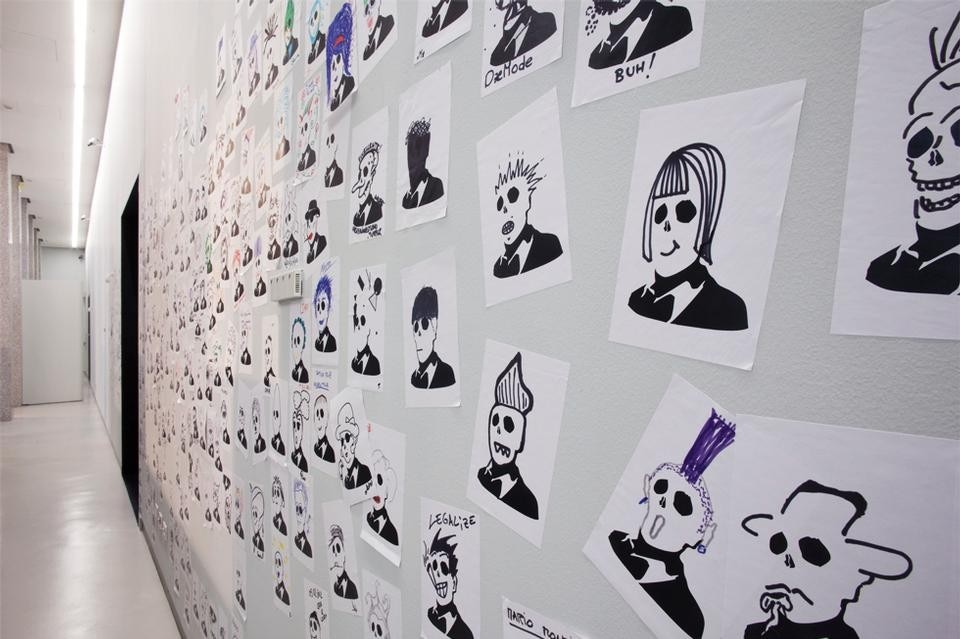 Gli sticker-firma di Ozmo personalizzati dagli utenti e installati sulle pareti dello Spazio Mostre del Museo del Novecento. Foto Giulia Ticozzi/Il Post