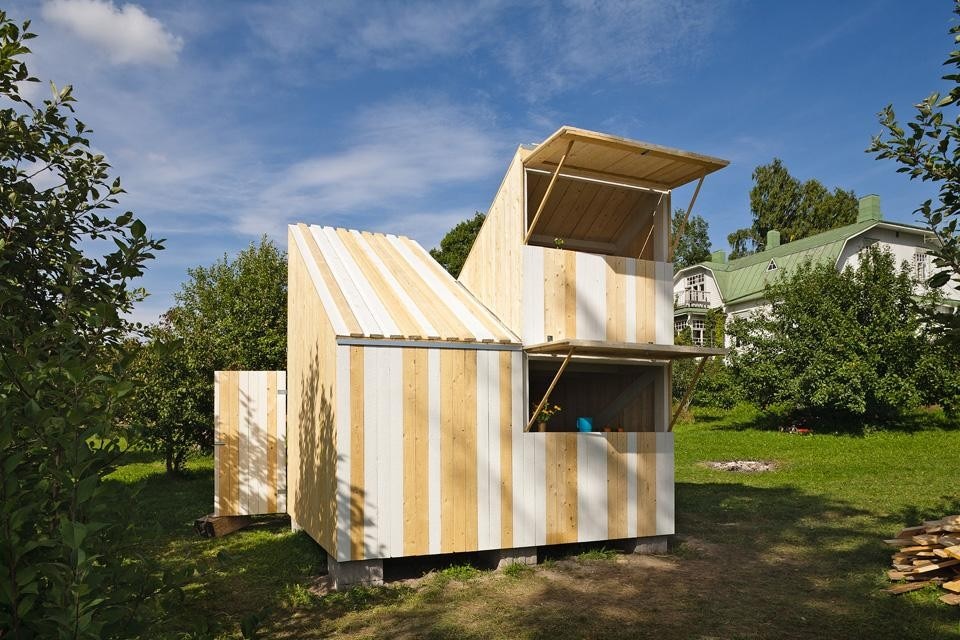 La casa è stata dipinta a strisce bianche verticali, che arrivano sul tetto e aiutano a comprendere la sezione originale del progetto