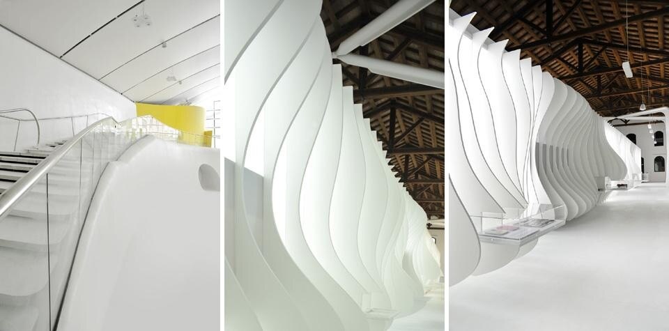 A sinistra: la vista per i visitatori che entrano nella Galleria si presenterà ininterrotta e panoramica su tutta l’esposizione: un ampio, continuo spazio bianco.  Al centro e a destra: l’allestimento dell'Officina e’ un muro sinuoso suddiviso da pagine verticali, questo paesaggio tridimensionale, illuminato in modo tenue,  occupa l’intera lunghezza dell’officina (40 metri)