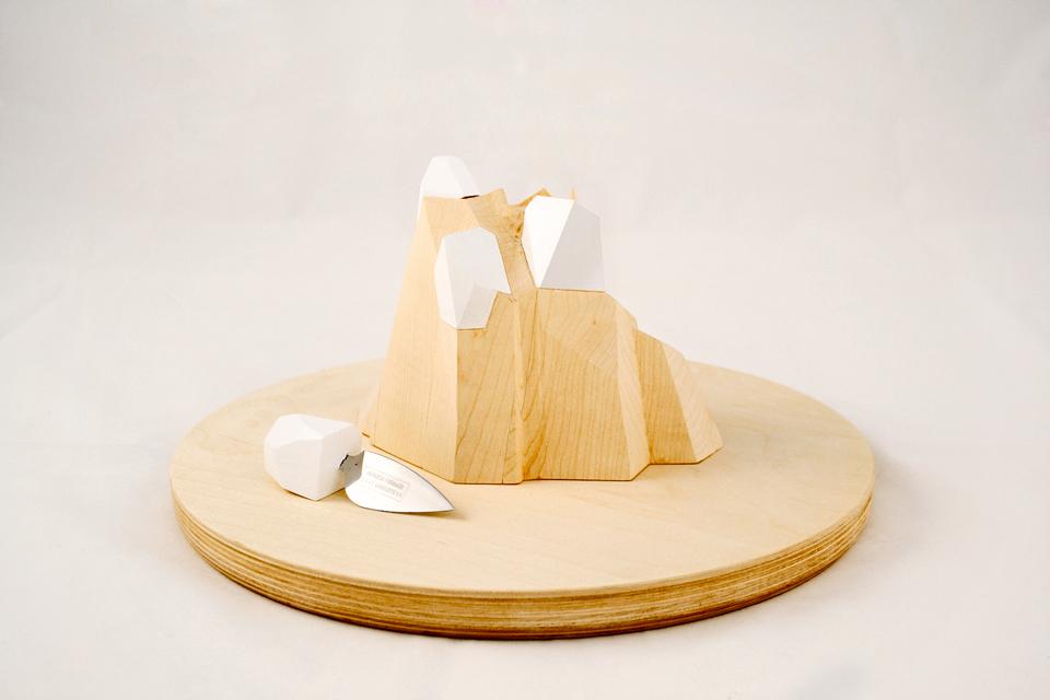 Apparecchiare la città di studio Ghigos ideas: figurazioni di “montagna”. Un ceppo che accoglie i coltelli da formaggio è integrato al tagliere,
ora “elevato” al rango di vassoio.
I singoli manici dei coltelli simulano ghiacciai d’alta quota,
mentre “a valle” il grana si propone in frammenti pregiati tutti da
assaporare. Prototipo