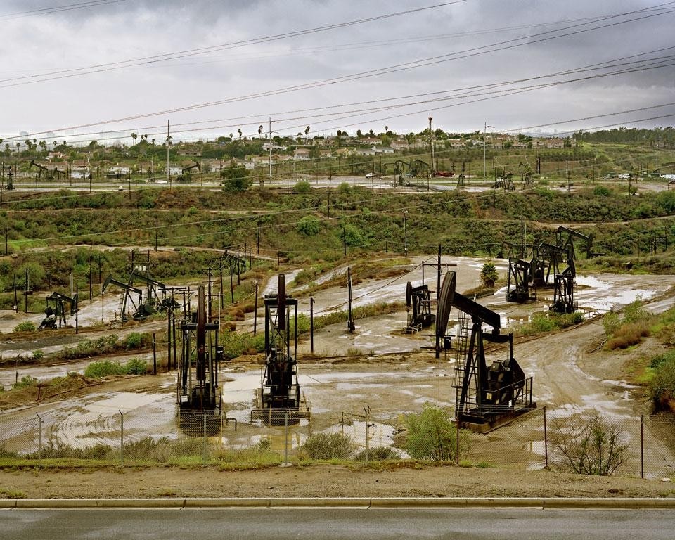 Niccolò Morgan Gandolfi
<i>LA Look</i>, December 2009, South La Cienega Blvd, Inglewood, CA, US. A poche miglia dall’aeroporto
(LAX), guidando verso la
città, s’incontra una vasta
area di pozzi petroliferi che si
alterna con aree residenziali.
L’Inglewood Oil Field copre
quasi mille acri di terreno,
aggiudicandosi il primato del
più grande giacimento contiguo
a uno spazio urbano negli Stati
Uniti. Oggi, l’area è soggetta
a progetti di miglioramento
paesaggistico