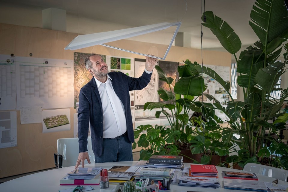 Mario Cucinella con la lampada Flexia, progettata per Artemide