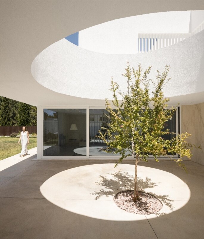 The house designed by Estúdio AMATAM in Portugal is built around empty spaces