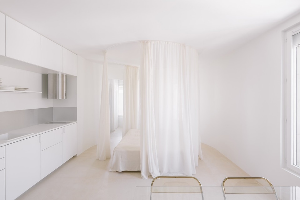 L’attico piccolo e bianco di Atelier Kibum Park ha un letto a baldacchino in cucina